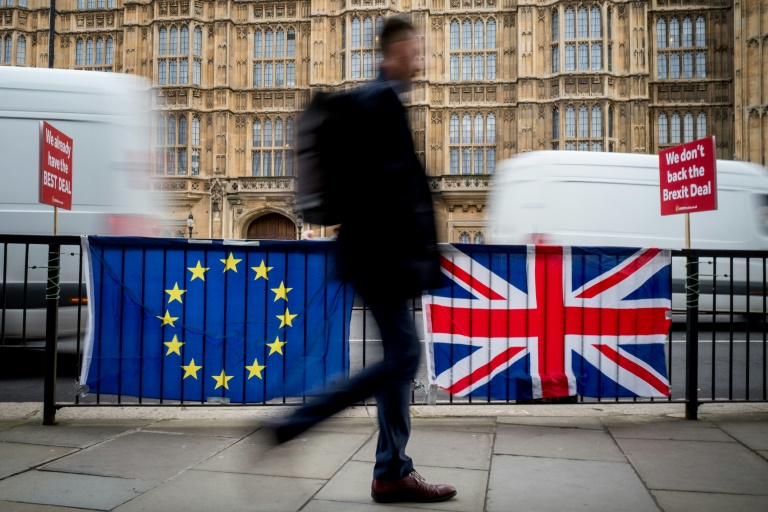 Pedestre passa por bandeiras da União Europeia e do Reino Unido, em Londres