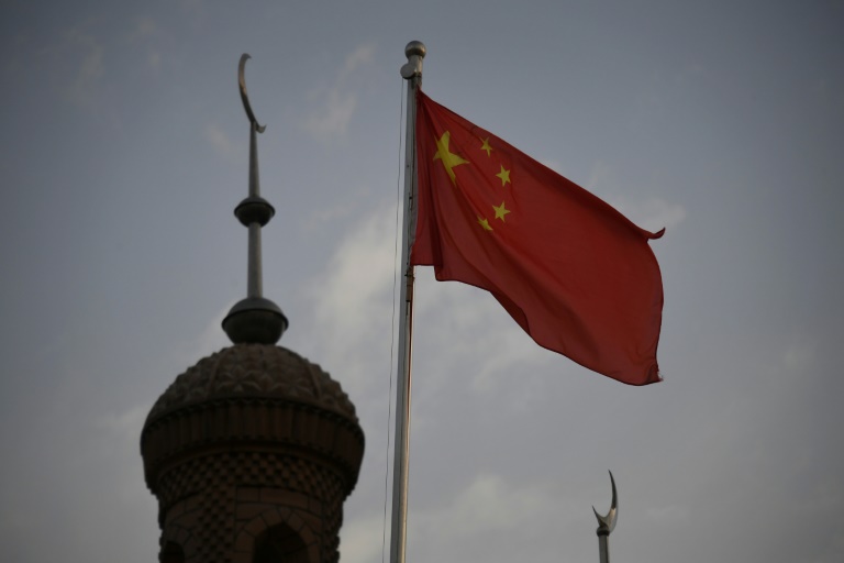 Bandeira chinesa sobrevoando a mesquita Juma na área restaurada da cidade velha de Kashgar, na região oeste da China, em Xinjiang