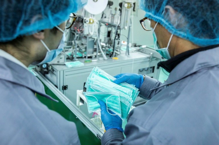 Trabalhadores inspecionando máscaras cirúrgicas recém-fabricadas em Hong Kong