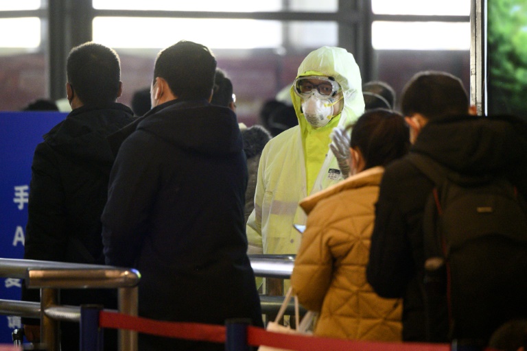 coronavírus Médicos examinam passageiros que chegam de trem a Xangai