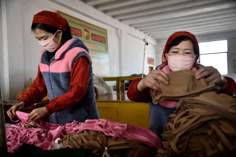 Trabalhadores da Fábrica de Malhas Songyo em Pyongyang produzem máscaras para proteção contra o novo coronavírus