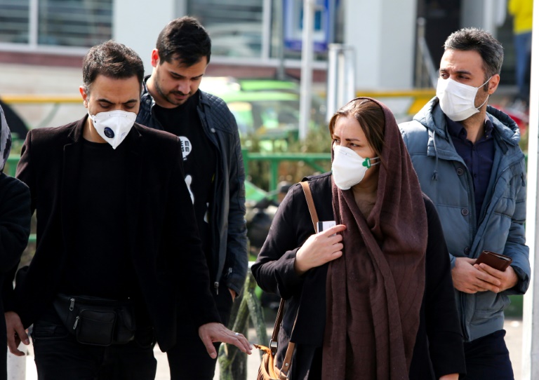 Iranianos, alguns usando máscaras de proteção, em Teerã