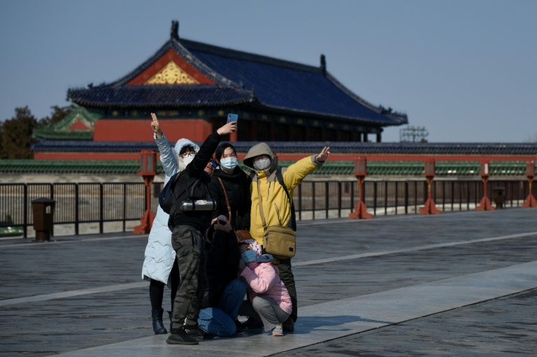 Grupo de visitantes com máscaras de proteção tira foto em um parque de Pequim, em 15 de fevereiro de 2020
