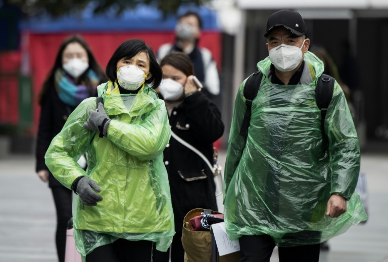 Pessoas que usam máscaras protetoras chegam a uma estação ferroviária em Xangai