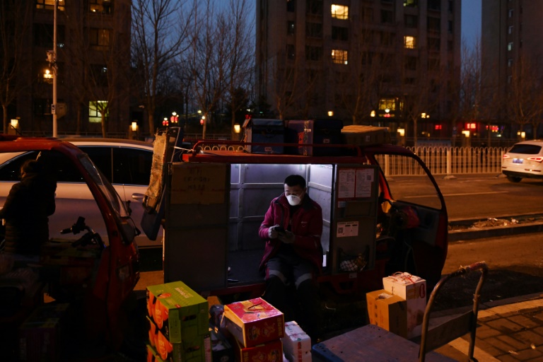 Um entregador de comida entrega pacotes em um complexo residencial em Tongzhou, no leste de Pequim