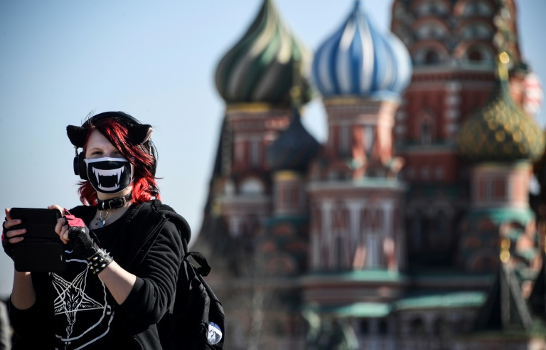 Uma jovem usando uma máscara de proteção caminha em Moscou