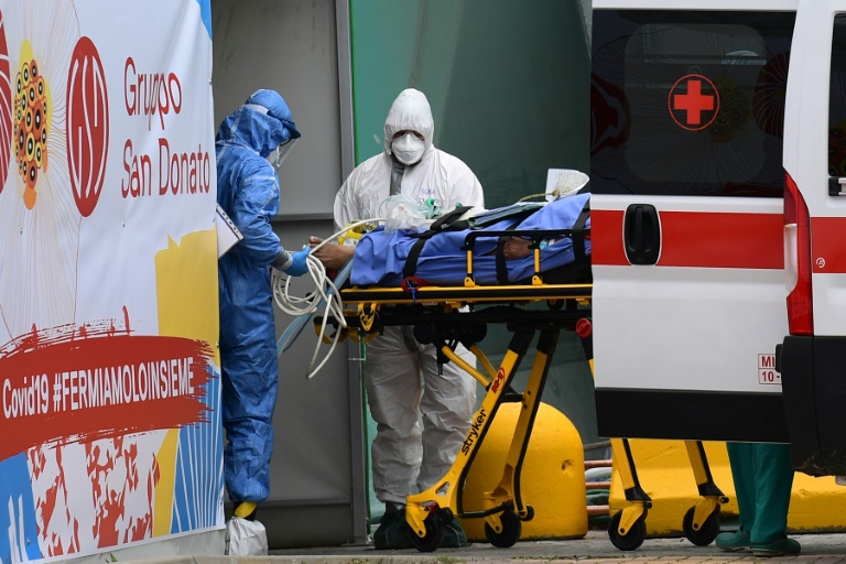 Médicos transportam um paciente de ambulância da Cruz Vermelha Italiana para uma unidade de terapia intensiva em Milão