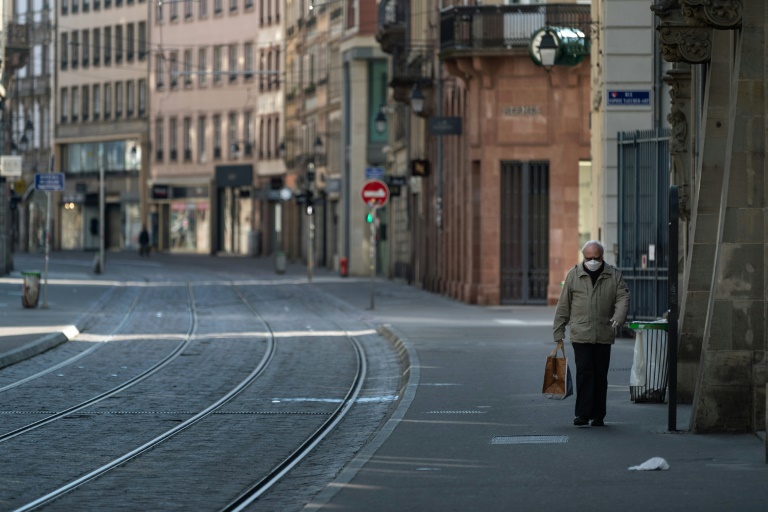 Homem com máscara em rua deserta do centro de Estrasburgo, França