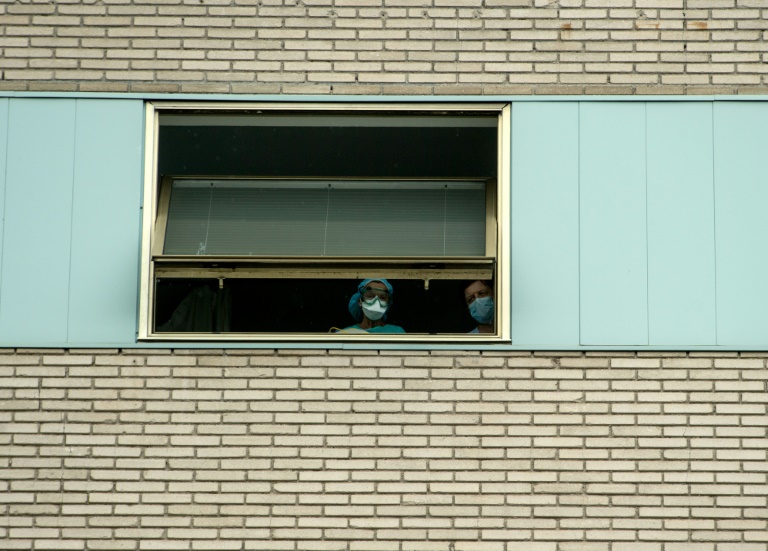 Funcionários na janela do Hospital Gregorio Marañón de Madri, na Espanha