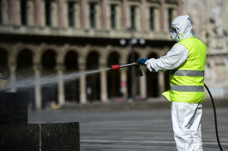 Funcionário limpa a praça Duomo em Milão em 31 de março de 2020