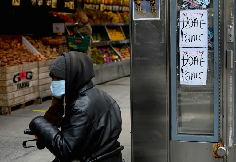 Homem usa máscara em frente a uma mercearia em Nova York, 16 de abril de 2020