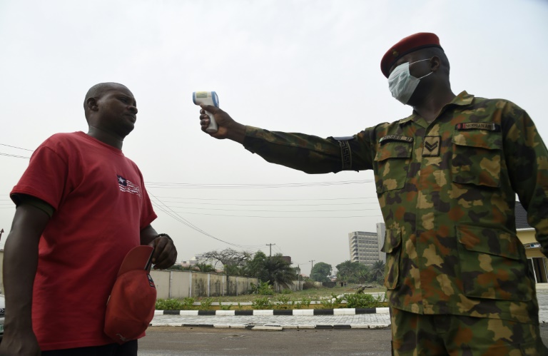Soldado verifica a temperatura corporal de um visitante do Hospital de Referência do Exército em Yaba, Lagos, em 28 de fevereiro de 2020