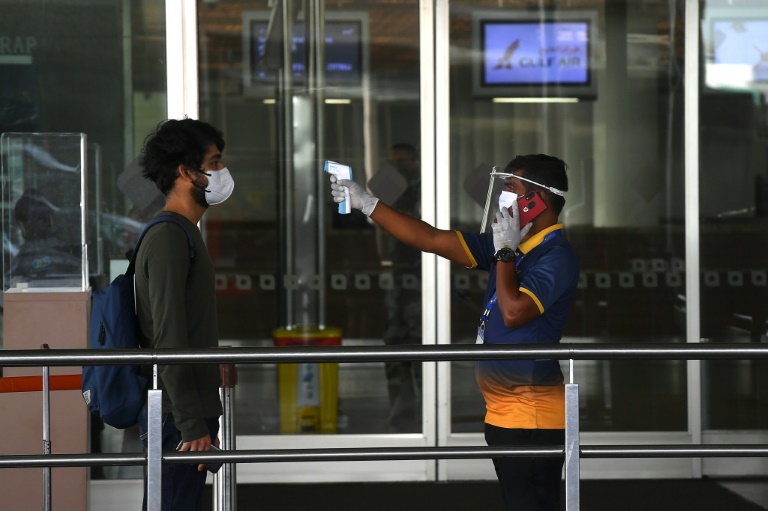 Funcionário do aeroporto da cidade indiana de Mumbai verifica Mumbai de um passageiro, em 25 de maio de 2020