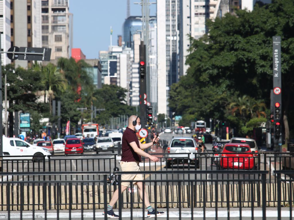 Pedestre passa pela Avenida Paulista usando máscara de proteção contra a Covid-19, em São Paulo