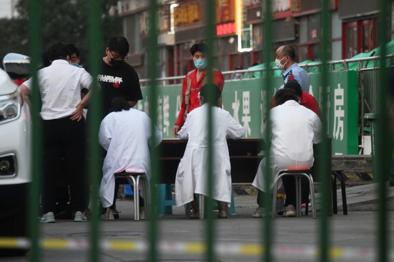 Autoridades se reúnem do lado de fora do mercado de carne Xinfadi, em Pequim, que foi fechado devido à temores de uma nova onda do coronavírus