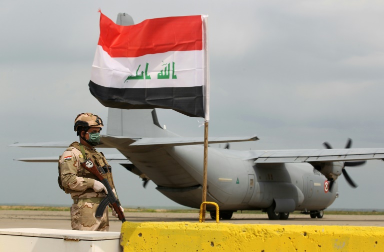 (Março) Soldado iraquiano em frente a avião militar dos Estados Unidos, na base aérea de Qayyarah, norte do Iraque