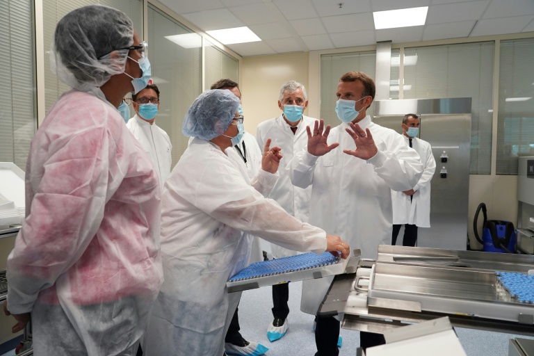 O presidente da França, Emmanuel Macron (D), conversa com cientistas no laboratório de desenvolvimento industrial da unidade de vacinas do grupo Sanofi Pasteur em Marcy-l'Etoile, em 16 de junho de 2020