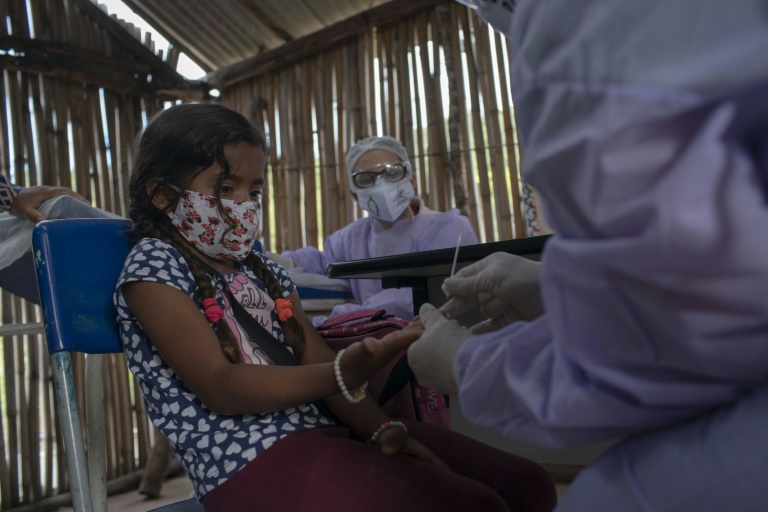 Profissional da saúde faz teste de COVID-19 em criança guarani, em Maricá