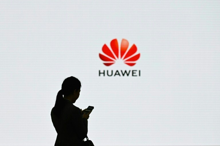 Silhueta de uma mulher em frente à logo da Huawei