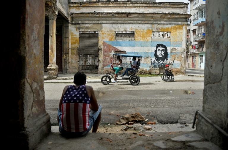 Vestindo camiseta com estampa da bandeira americana, um homem descansa em uma rua de Havana, em 21 de outubro de 2020
