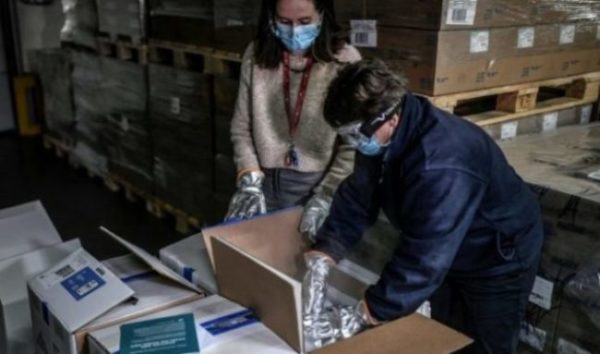 Trabalhadores abrem uma caixa da primeira remessa de vacinas da Pfizer-BioNTech na farmácia central AP-HP nos arredores de Paris, 26 de dezembro de 2020