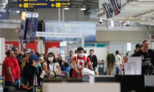 Passageiros e funcionários circulam vestindo máscaras contra a covid-19 no Aeroporto Internacional Tom Jobim- Rio Galeão viagem