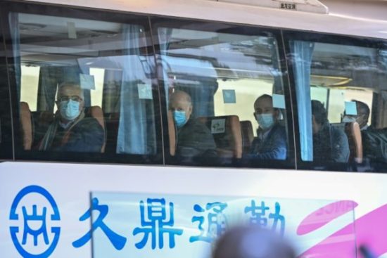 Especialistas da OMS deixam seu hotel em Wuhan após o fim da quarentena, em 28 de janeiro de 2021, para iniciar sua investigação