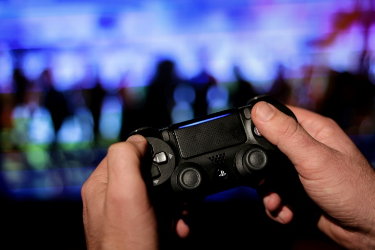 Um jogador usa um controle PS4 enquanto joga no novo videogame da Ubisoft "Watch Dogs Legion" em 28 de outubro de 2020
