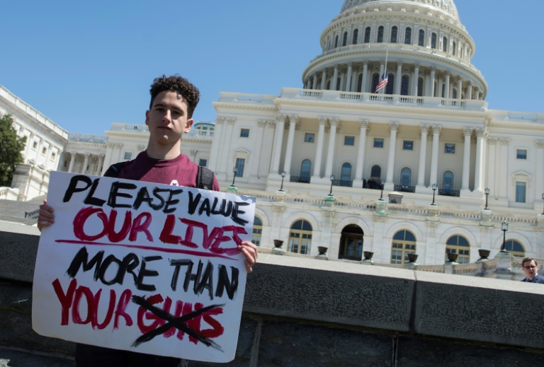 Amit Dadon, estudante da Marjory Stoneman Douglas High School, posa com o cartaz que diz "por favor, valorizem nossas vidas mais do que suas armas"