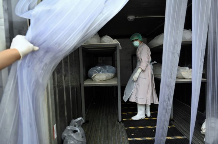 Funcionários retiram os corpos de vítimas da covid-19 de um contêiner refrigerado para colocá-los em caixões, no hospital Thammasat, na província de Pathum Thani, Tailândia, em 4 de agosto de 2021