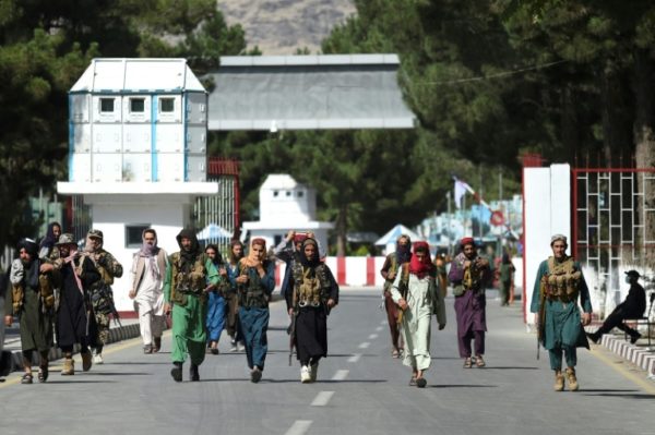 Combatentes talibãs caminham no portão principal do aeroporto internacional de Cabul