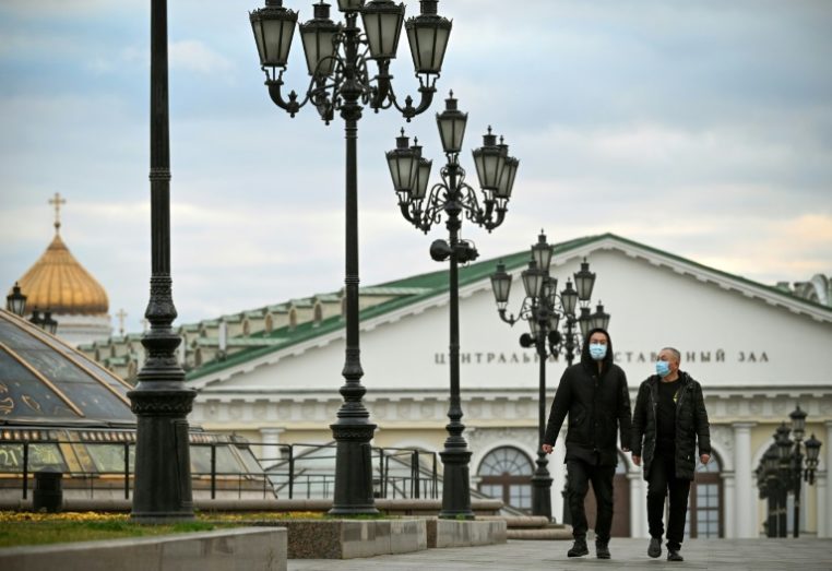 Russos de máscara caminham pelo centro de Moscou em 22 de outubro de 2021