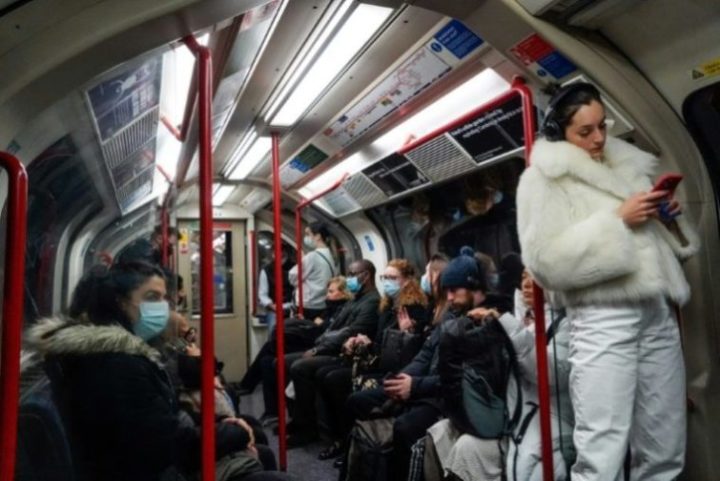 Passageiros com máscara e sem em vagão do metrô em Londres nova variante