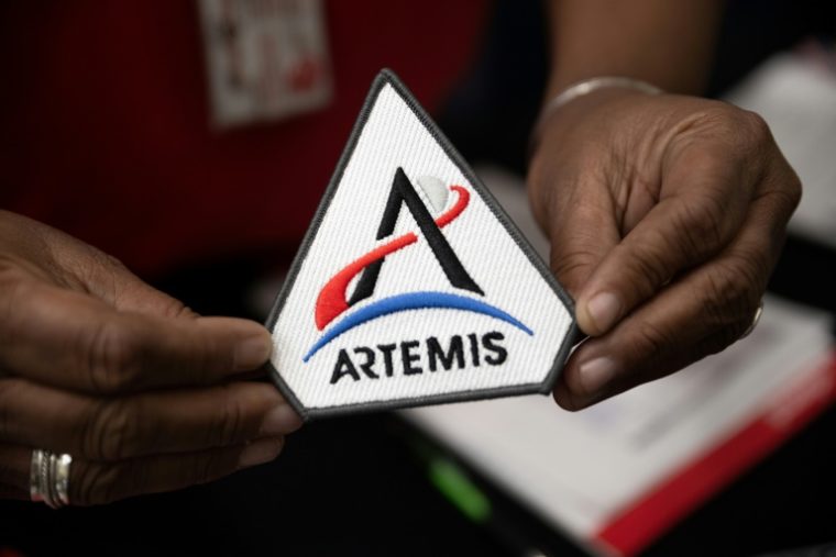 Funcionário da agência espacial americana mostra logotipo do programa lunar Artemis, em março de 2014