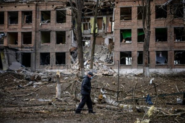 Homem caminha diante de edifício destruído após ataque de míssil russo na cidade de Vasylkiv, perto de Kiev
