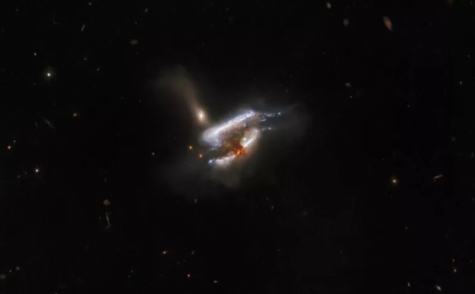 Com um movimento em espiral através do espaço, três galáxias distantes se chocam e se unem numa nova e fascinante fotografia captada pelo Hubble