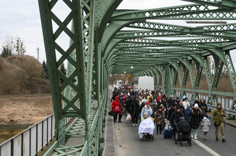 Refugiados ucranianos atravessam ponte na fronteira com a Polônia, na região de Zosin-Ustyluh