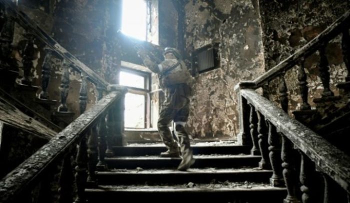 Foto foi tirada durante uma incursão organizada pelos militares russos. Um soldado russo sobe escadas no teatro Mariupol, atingido em 16 de março por um ataque aéreo, em 12 de abril de 2022 em Mariupol
