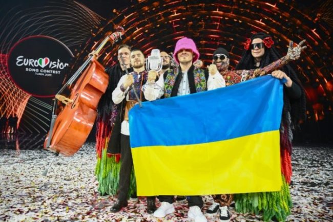 Membros do 'Kalush Orchestra' posam no palco com o troféu de vencedor e a bandeira da Ucrânia depois de vencerem em nome do país o Festival Eurovision em 14 de maio de 2022, na Itália - AFP