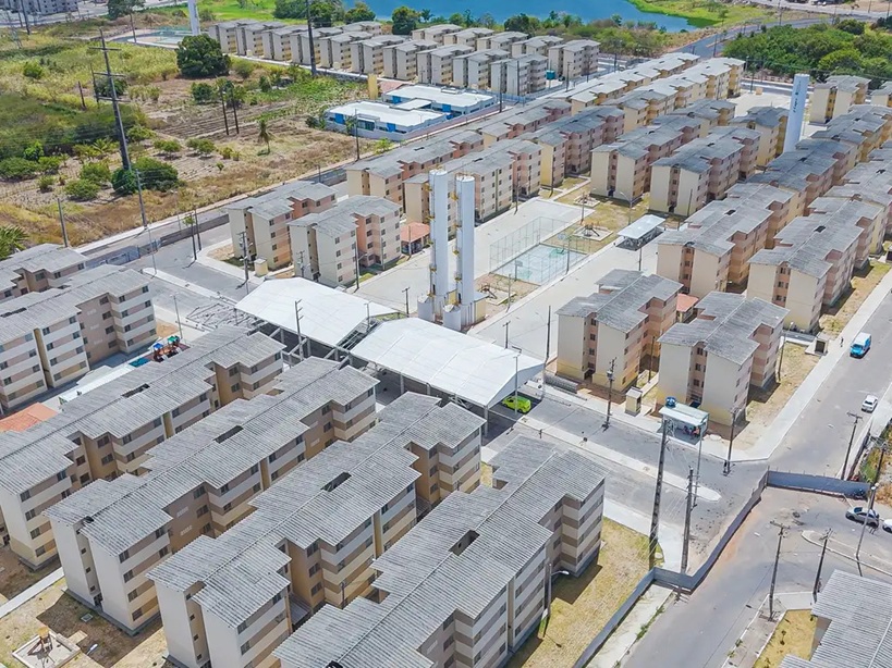 A fotografia exibe uma imagem aérea de um condomínio residencial do Minha Casa, Minha Vida