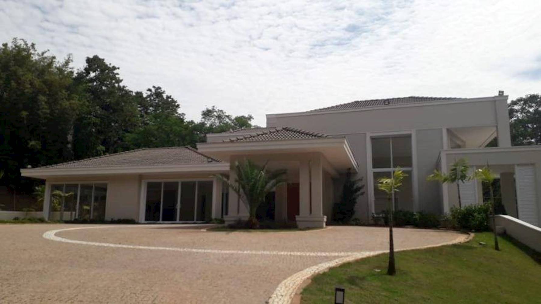 Fotografia da casa do leilão. A casa tem uma fachada imponente, alta, com uma grande pista na frente. É a casa mais cara do leilão, com 544 metros quadrados