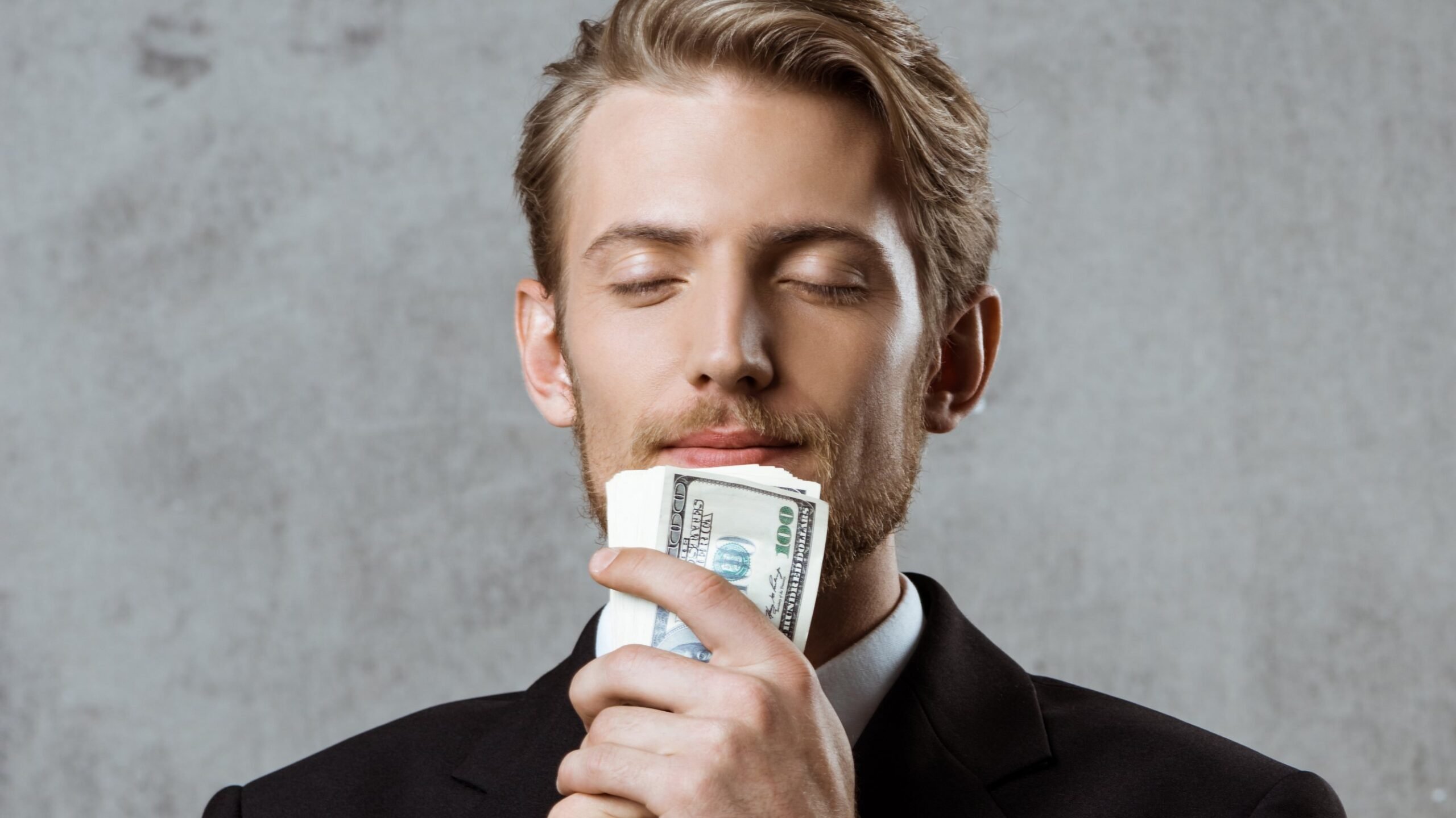 homem rico segura notas de dólar