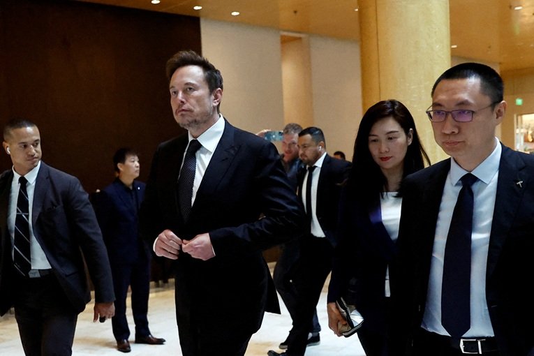 Diretor Executivo da Tesla, Elon Musk, caminha ao lado do Vice-Presidente Sênior da Tesla, Tom Zhu, e da Vice-Presidente Grace Tao ao deixar um hotel em Pequim, China. 31/05/2023