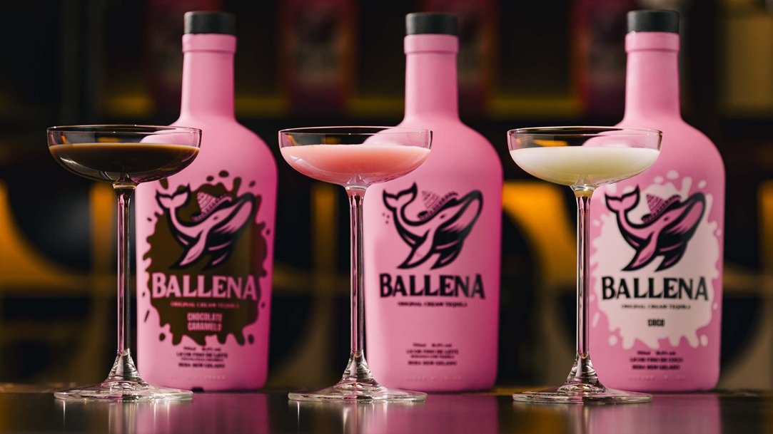 Fotografia de garrafas dos três sabores de Ballena. Na frente de cada uma, vemos um copo servido com as respectivas bebidas, nas cores marrom, rosa e branco