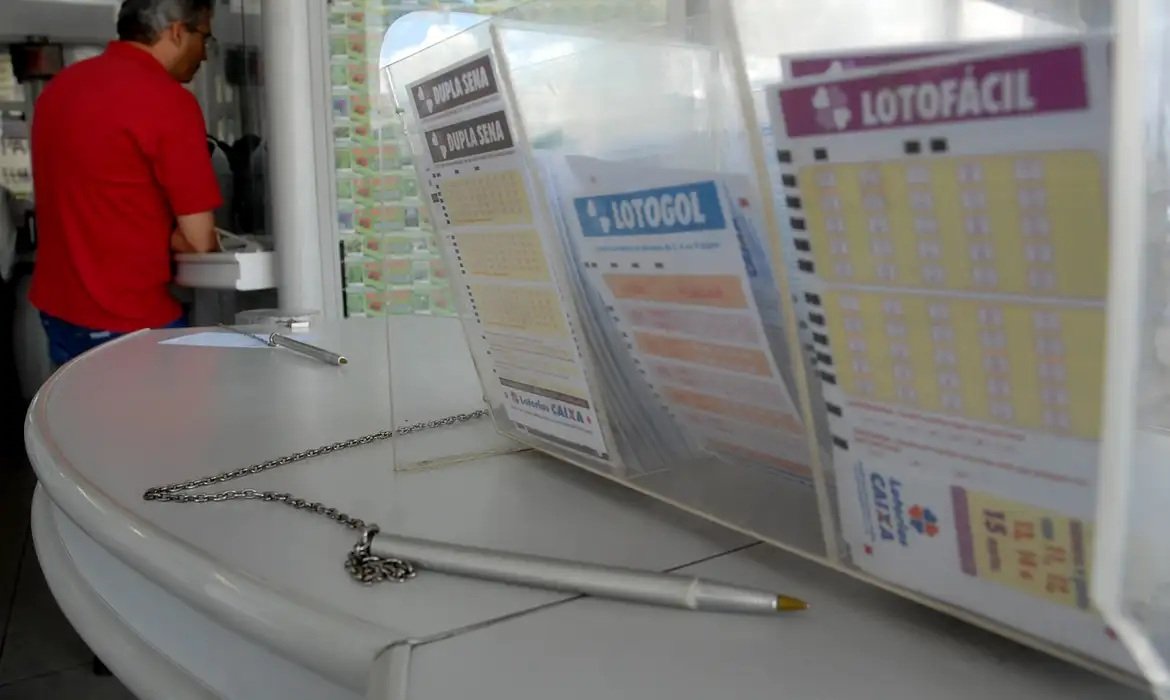 Fotografia de bilhetes em uma unidade das Loterias Caixa. Os bilhetes são da Lotofácil, Lotogol e Lotomania