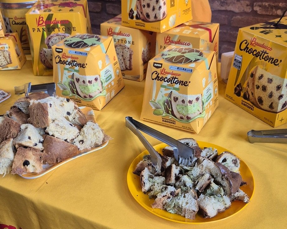Fotografia de uma mesa com caixas de chocottone (ou panetone) de pistache da Bauduco