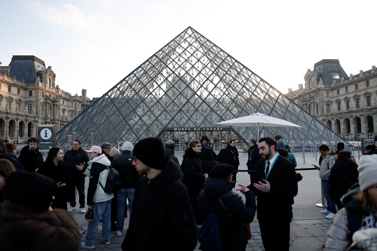 Pessoas próximas à Pirâmide de vidro do Museu do Louvre, em Paris, durante reunião de funcionários sobre greve