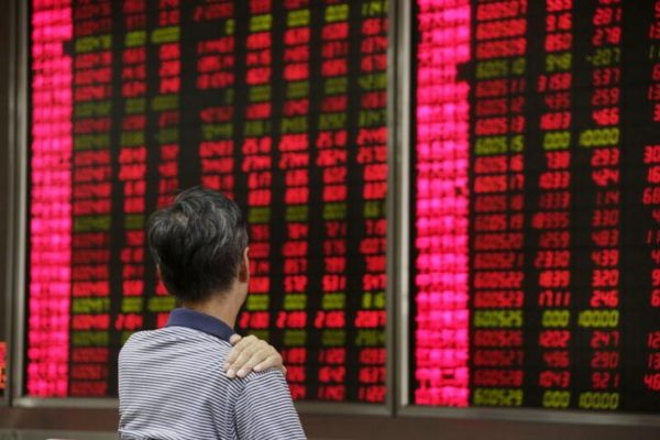 Investidor acompanha telão com flutuações dos mercados em corretora de Pequim