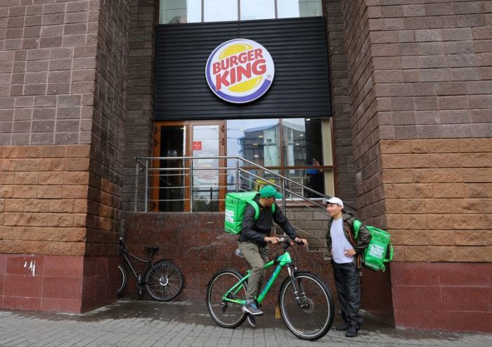 Entregadores de comida do lado de fora de uma unidade do Burger King em Moscou