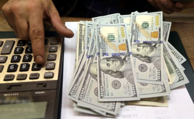 Pessoa conta notas de dólares em casa de câmbio no Cairo